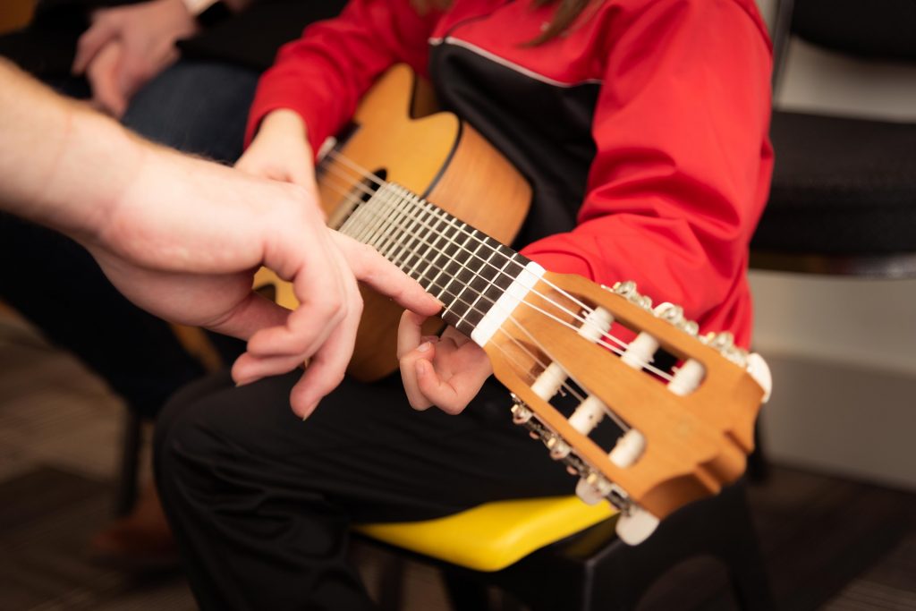 Child Taking a Guitar Lesson